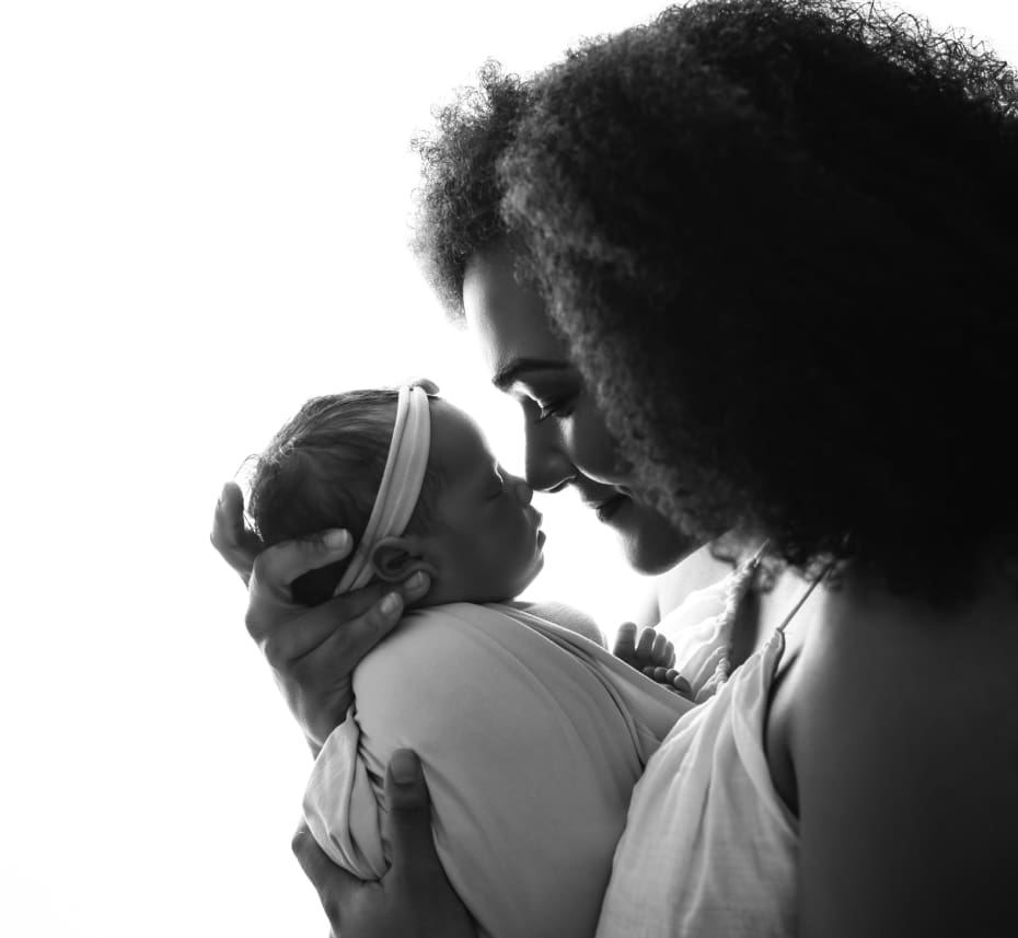 A woman holding a baby in her arms.